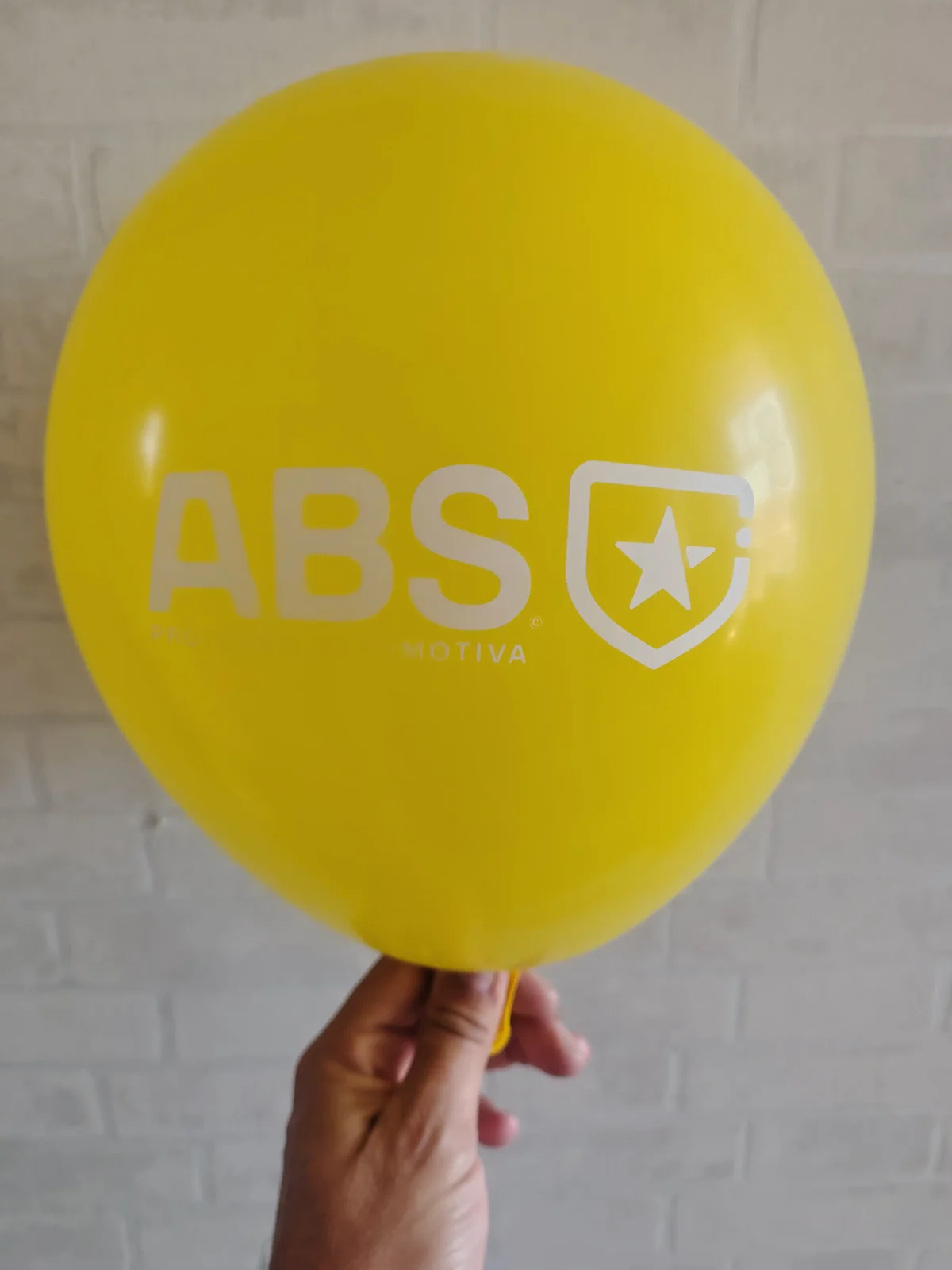 Balão amarelo com a marca ABS Proteção Automotiva e impressão branca