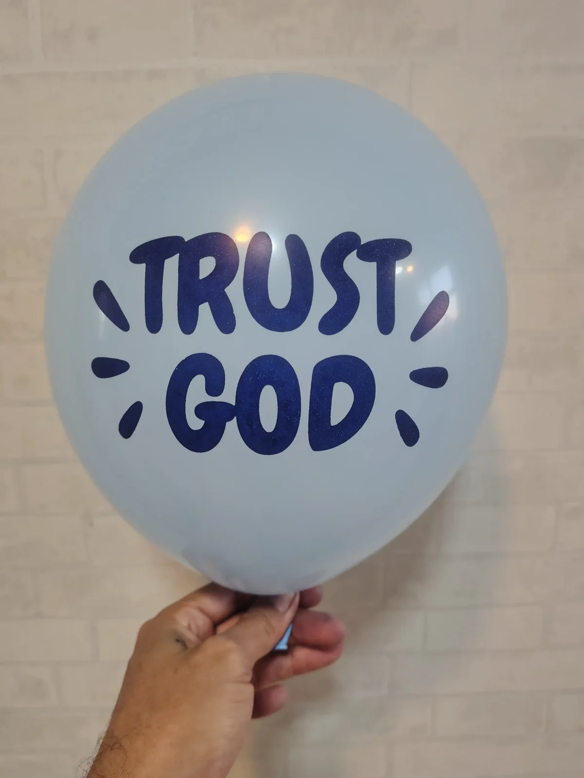 Balão azul-claro com a mensagem Trust God em azul