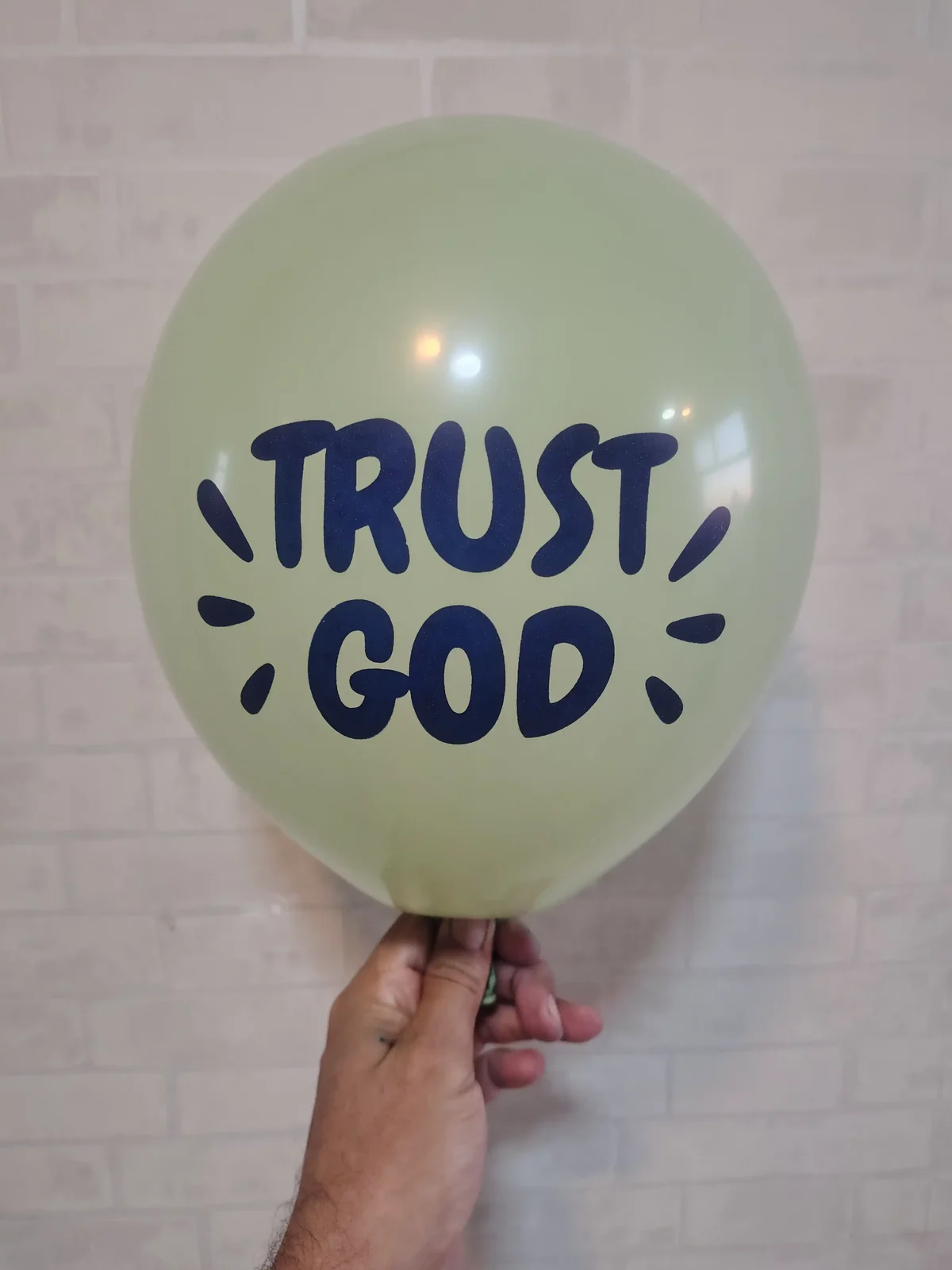 Balão verde-claro com a mensagem Trust God em azul