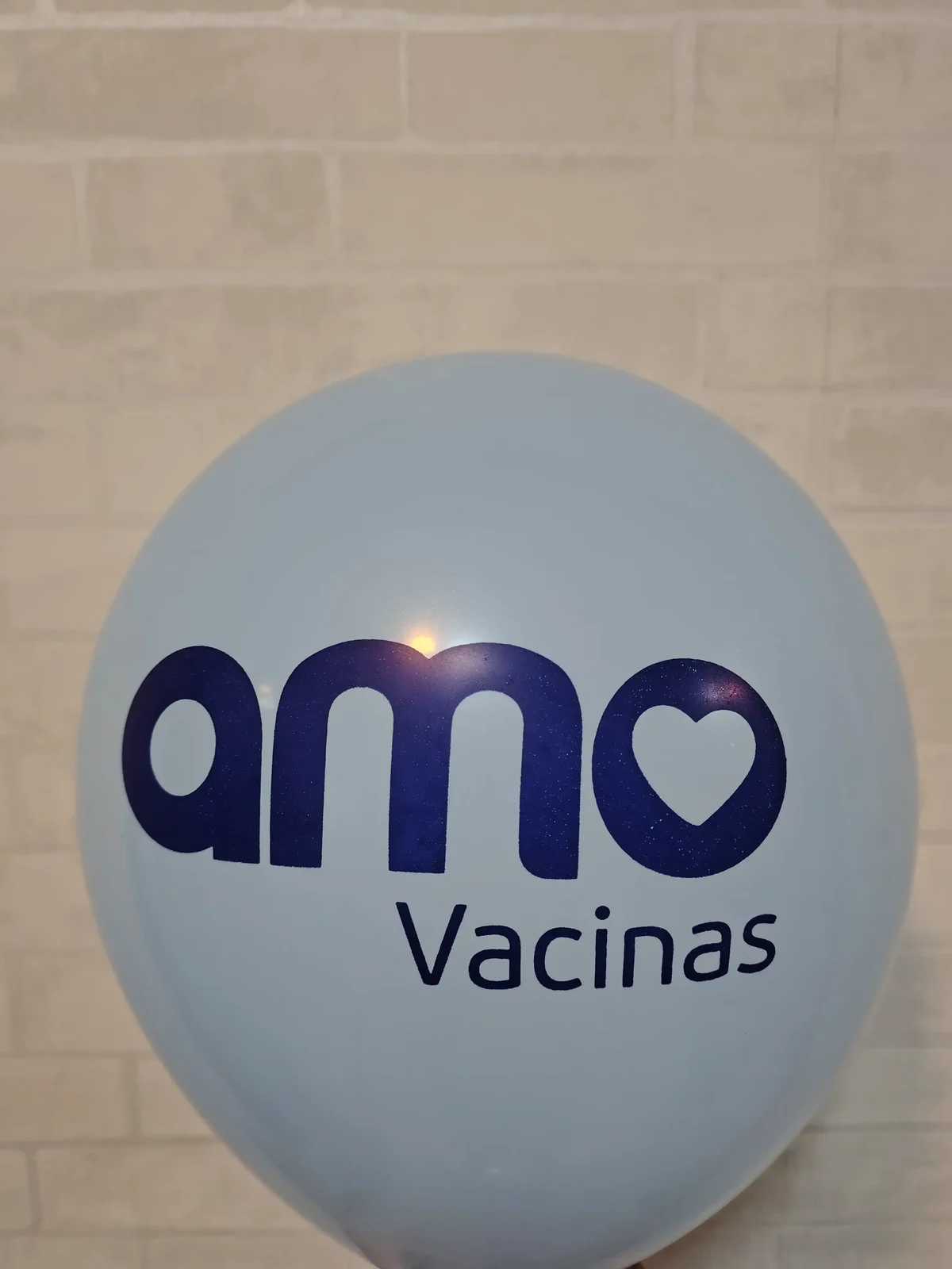 Balão azul-claro com a marca Amo Vacinas